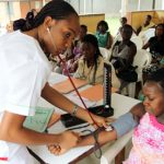 A nurse checks a pregnant woman's blood pressure at a maternity hospital in Nigeria.